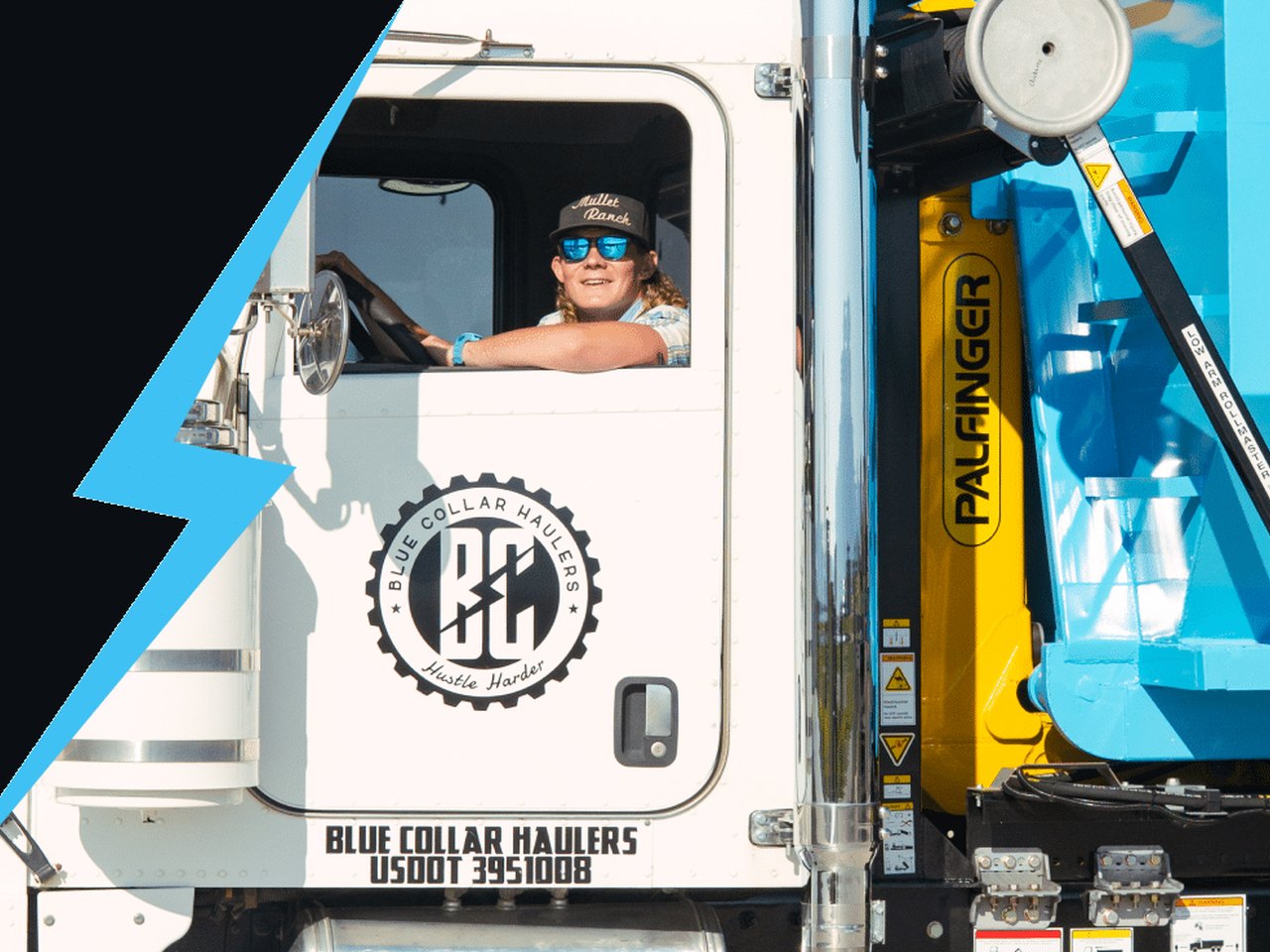 Blue Collar Haulers driver in the truck cab with a cyan roll-off dumpster loaded